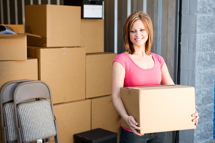 Woman moving boxes into storage unit.